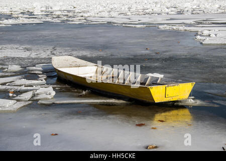 Donau, Serbien - ein gelbes Boot gefangen in einem gefrorenen Fluss Stockfoto