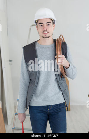 Porträt der schönen Klempner mit verstellbaren Schraubenschlüssel und Rohr Stockfoto