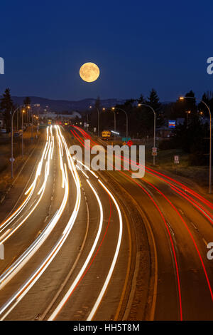 Vollmond-Einstellung über Verkehr am Transcanada Highway in Victoria-Victoria, British Columbia, Kanada. Stockfoto