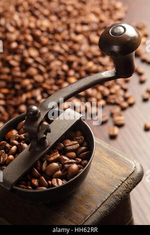 Foto von einer antiken Kaffeemühle mit Kaffeebohnen in den unscharfen Hintergrund. Stockfoto