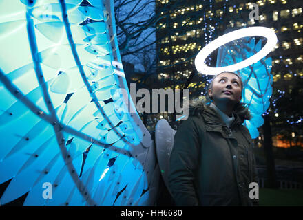 Amy Penn, 24 aus London steht bei Angels from Freedom by OVE Collective beleuchtet im Jubilee Park in Canary Wharf, London, im Rahmen des Winter Lights Festivals 2017, das heute für die Öffentlichkeit kostenlos geöffnet ist und bis zum 27. Januar läuft. Stockfoto