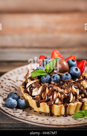 Banoffee Pie (Herb) dekoriert mit Schokolade, frischen Heidelbeeren und Erdbeeren Stockfoto