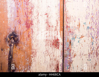 Detail von einer alten Holztür mit Schichten über Schichten von Farbe, die leicht versandet worden Stockfoto
