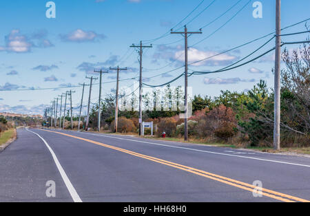 eine lange und gerade Montauk Highway mit einer begleitenden elektrischen Leitung und Stangen Stockfoto