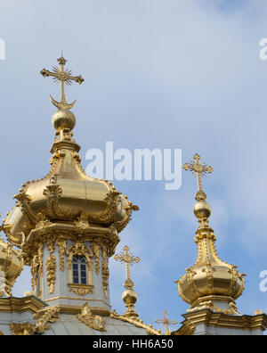 Nahaufnahme von der goldenen Zwiebeltürme auf die Schlosskapelle im Peterhof Palace. Kuppeln gekrönt mit kreuzt orthodoxe gegen blauen Himmel. Stockfoto