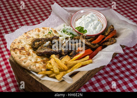 Hausgemachte griechische Fleisch Gyros mit Tzatziki Sauce, Tomaten und Pommes frites Stockfoto