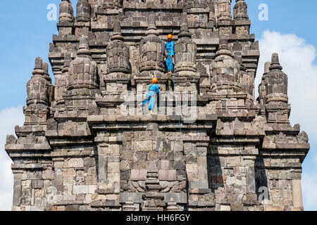 Arbeitnehmer in blau Arbeit Mäntel sind Reinigung eine der Vishnu Heiligtümern der Prambanan Tempel komplex. Java, Indonesien. Stockfoto