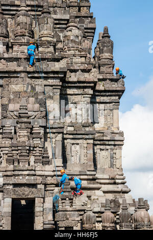 Arbeitnehmer in blau Arbeit Mäntel sind Reinigung eine der Vishnu Heiligtümern der Prambanan Tempel komplex. Java, Indonesien. Stockfoto