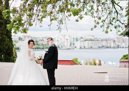 Brautpaar bleiben unter Baum Hintergrund Stadt See. Stockfoto