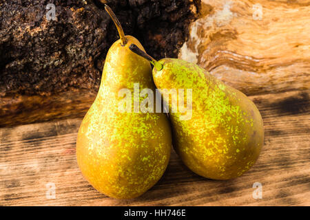Zwei süß schmeckende und reife Birnen (Pyrus Communis) auf Holzbrett. Birnen sind der englische Sorte Conference, oft verwendet als Dessert oder in co Stockfoto