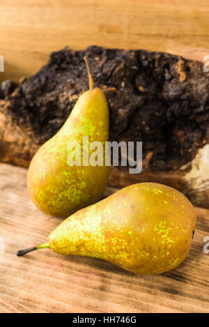 Zwei süß schmeckende und reife Birnen (Pyrus Communis) auf Holzbrett. Birnen sind der englische Sorte Conference, oft verwendet als Dessert oder in co Stockfoto