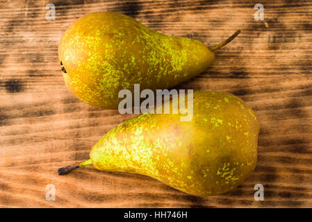 Zwei süß schmeckende und reife Birnen (Pyrus Communis) auf Holzbrett. Birnen sind der englische Sorte Conference, oft verwendet als Dessert oder in co Stockfoto