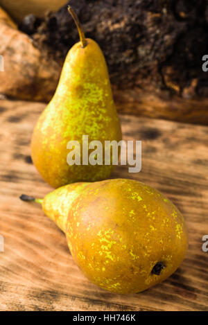Zwei süß schmeckende und reife Birnen (Pyrus Communis) auf Holzbrett. Birnen sind der englische Sorte Conference, oft verwendet als Dessert oder in co Stockfoto