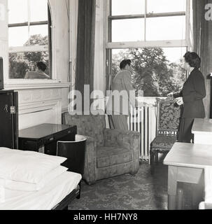1950er-Jahren, historische, mögliche neue Quartiere, prüft ein neu angekommener Übersee männliche Student nach Großbritannien den Blick aus dem Schlafzimmerfenster. Stockfoto