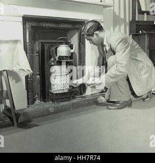 1950, historische, kamen neu Übersee indischen Doktorand am Institut der Ausbildung (IOE) Versuche, ein Gasfeuer anzuzünden um einen Wasserkocher in seine Wohnung zu heizen. Stockfoto