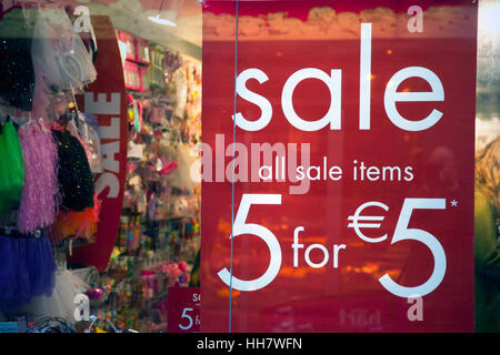 Verkaufsschild auf Shop Fenster und farbenfrohe Artikel voll drin Stockfoto