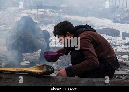 Belgrad, Serbien. 17. Januar, 2017. Flüchtlinge stehen in der Schlange für das Essen außerhalb ein verfallenes Lagerhaus, in dem sie Unterschlupf fand verteilt Stockfoto