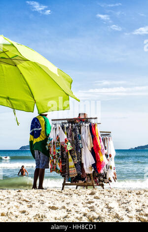 Strandverkäufer mit brasilianischer Flagge am Acores Beach. Florianopolis, Santa Catarina, Brasilien. Stockfoto