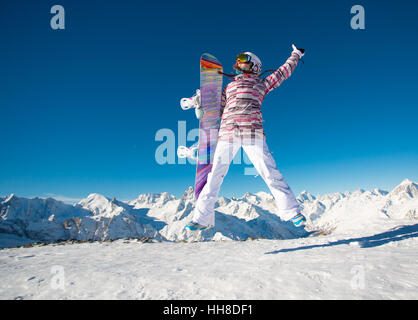 Junges Mädchen Snowboarder in den alpinen Bergen springen. Stockfoto