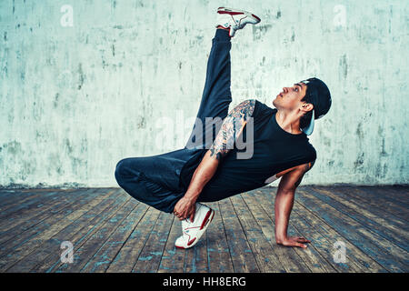 Junger Mann Breakdance auf Wand Hintergrund. Tattoo auf den Körper. Stockfoto