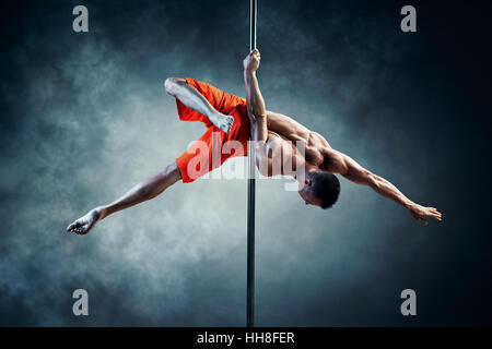 Junge starke Pole dance Mann mit Rauch-Effekt Stockfoto