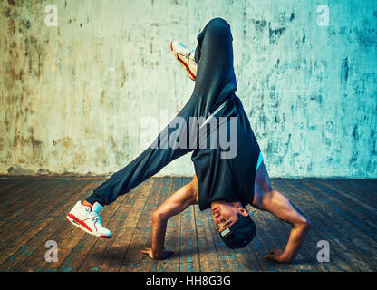 Junger Mann Breakdance auf Wand Hintergrund. Tattoo auf den Körper. Stockfoto