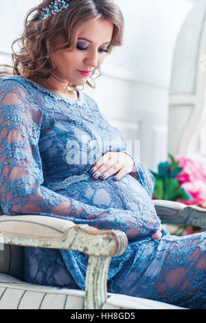 Junge schwangere Frau drinnen Porträt Stockfoto