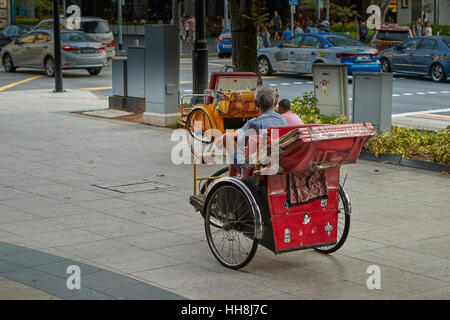 Zwei Zyklus Rickshaw Hausierer warten in Singapur. Stockfoto