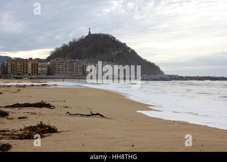 Schwellen und bewölkten Tag mit einigen Leuten zu Fuß an der Küste in Donostia (Guipuzcoa, Baskenland, Spanien). Stockfoto