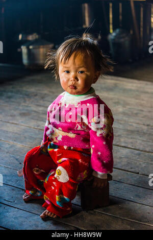 Kleines Mädchen sitzt auf Schemel in Hütte, Palaung Bergvolk, Palaung Dorf in Kyaukme, Shan State in Myanmar Stockfoto