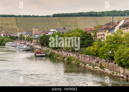 Leute sitzen am Ufer des Mains am Abend in Würzburg, untere Franken, Bayern, Deutschland Stockfoto