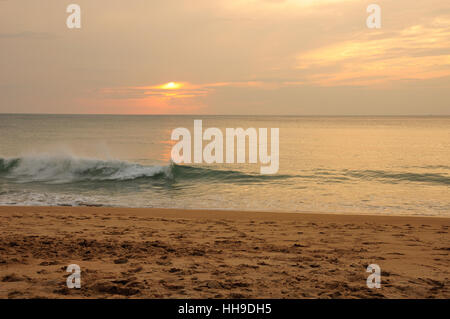 Die untergehende Sonne spiegelt aus der Andamanensee aus Phuket Thailand am Mai Khao Beach. Stockfoto