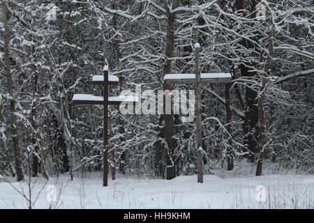 zwei Holzkreuze Symbol der union Religion bleiben im tiefen Schnee in der Nähe von Straße Stockfoto