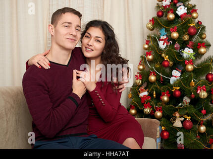 Glückliches Paar in Weihnachts-Dekoration zu Hause. Silvester, geschmückten Tannenbaum. Winter Urlaub und Liebe Konzept. Stockfoto