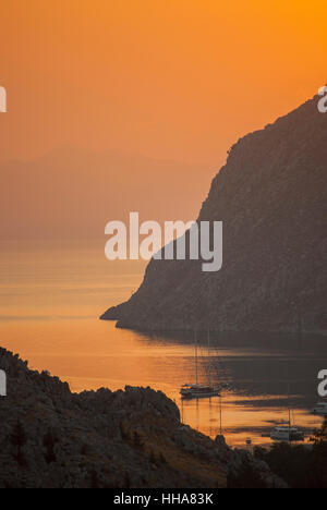 Morgendämmerung über der türkischen Küste von Chorio nach Pedi auf Symi Griechenland blickte. Stockfoto