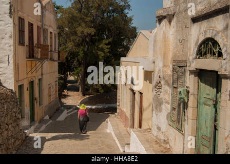 Single-Frau mit grünem Hut und rosa Bluse. Fuß des Kalistrata auf Symi Griechenland Stockfoto