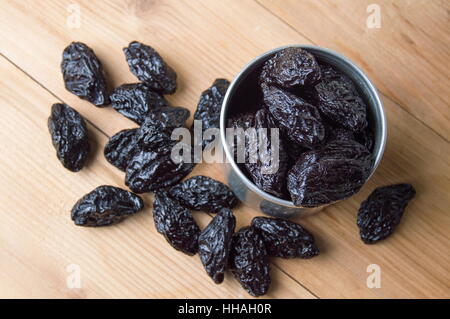 Getrocknete Pflaumen in einer Metalldose auf dem Tisch Stockfoto