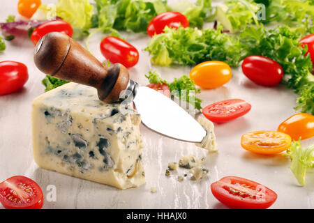 Blauschimmelkäse-Stück mit Tomaten auf Stein Hintergrund und Platz für text Stockfoto