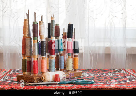 Mehrfarbige Nähgarne Vintage weiche Pastellfarben auf Spulen. Nähen-Schneider im Zusammenhang mit Zubehör. Stockfoto