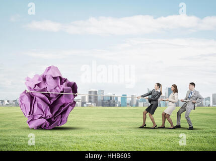 Junge Geschäftsleute im Freien und riesige Papier Kugel als Symbol der Kreativität Stockfoto