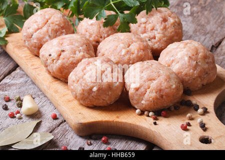 Rohe Frikadellen auf ein Schneidebrett und Zutaten. horizontale. Close-up Stockfoto