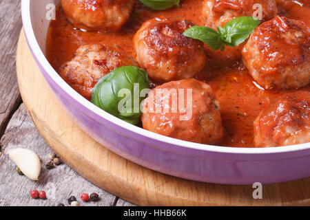 heiße Fleischbällchen mit Tomatensauce und Basilikum in einem Topf-Makro. horizontale Stockfoto