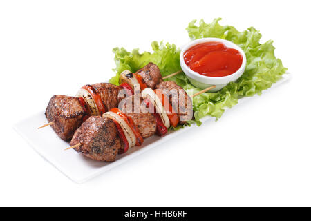 Schaschlik aus Schweinefleisch mit Gemüse und Sauce auf einem weißen Teller isoliert Stockfoto