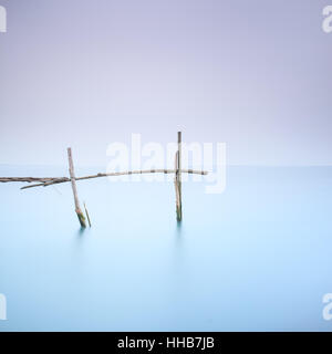 Angelruten für weiches Wasser, Muscheln und Muscheln auf einer ruhigen nebligen Landschaft. Langzeitbelichtung Fotografie Stockfoto