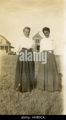 Antike 1908 Foto, zwei ältere Frauen vor Strandhäuser. Ort: New England, USA. QUELLE: ORIGINAL FOTOABZUG. Stockfoto