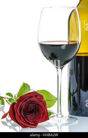 Schöne rote Rose und Weinglas Rotwein und eine Flasche auf einem weißen Hintergrund. Stockfoto