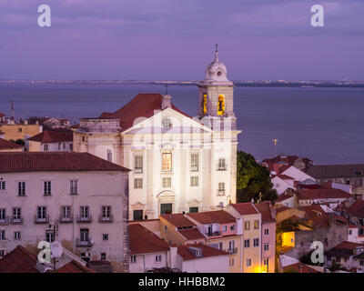 Igreja de Santo Estevao in Lissabon, Portugal, gesehen von Portas do Sol, bei Nacht. Stockfoto