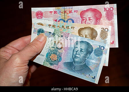 Hand, die chinesische Währung von 10, 20 und 100 Yuan noteswith Gleichnis des Vorsitzenden Mao Tse-tung. Stockfoto