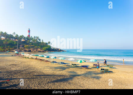 Liegestühle und Sonnenschirme Linie am Strand auf dem Sand im Hinblick auf die Wellen des Ozeans in Kovalam Licht Haus Strand in Kerala Stockfoto