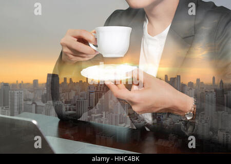 Doppelbelichtung Business-Frau trinken eine Kaffee und Sonnenaufgang Stadtbild. Stockfoto